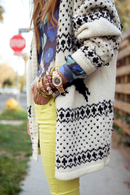 a street style shot of an arm party and fall sweater.