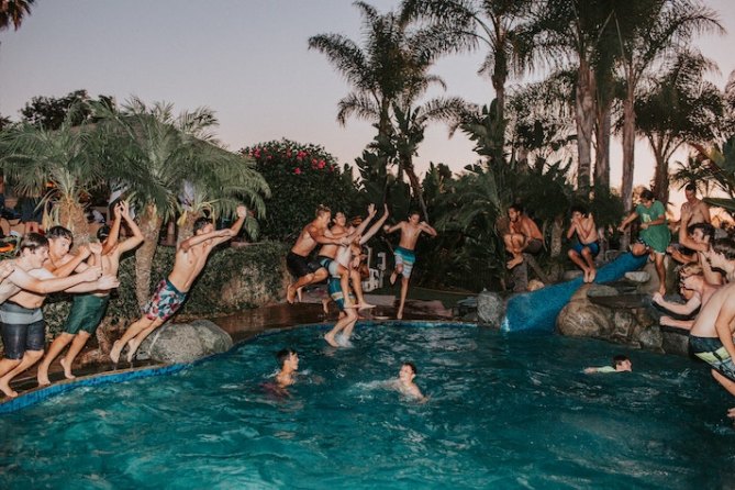 A group of people jumping in a pool