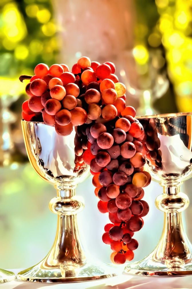 Two silver goblets full of grapes