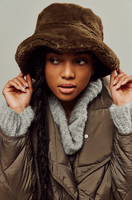 A model wearing a brown faux fur cowboy hat from Free People