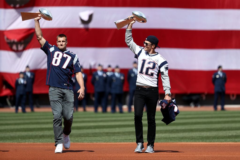 BOSTON, MA - APRIL 3: Rob Gronkowski #87 and Tom Brady #12 of the New England Patriots enter the field carrying Vince Lombardi trophies before the opening day game between the Boston Red Sox and the Pittsburgh Pirates at Fenway Park on April 3, 2017 in Boston, Massachusetts. (Photo by Maddie Meyer/Getty Images)