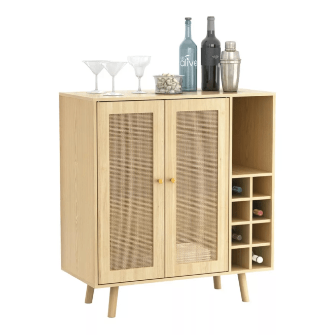 A light wood bar cabinet filled with bottles of wine and topped with barware