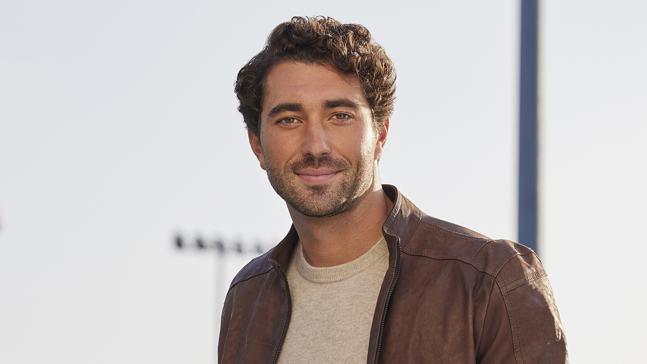 “The Bachelor” stars Joey Graziadei, a white man with brown hair and beard wearing a sweater to his jacket.