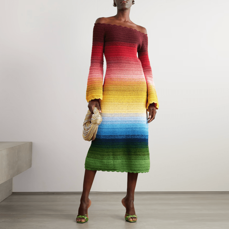 A model wearing an off-the-shoulder rainbow crochet dress