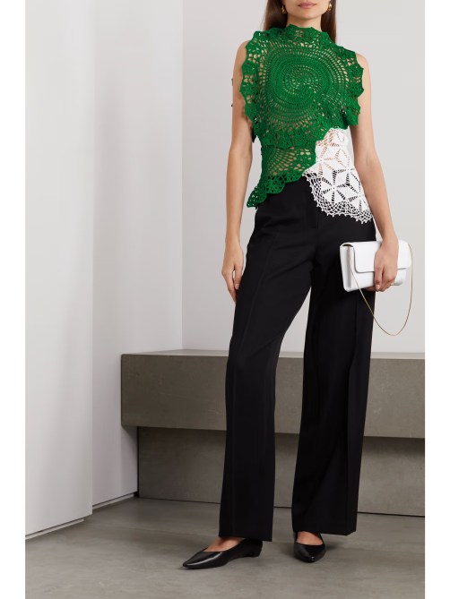 A model wears green and white crocheted lace top.