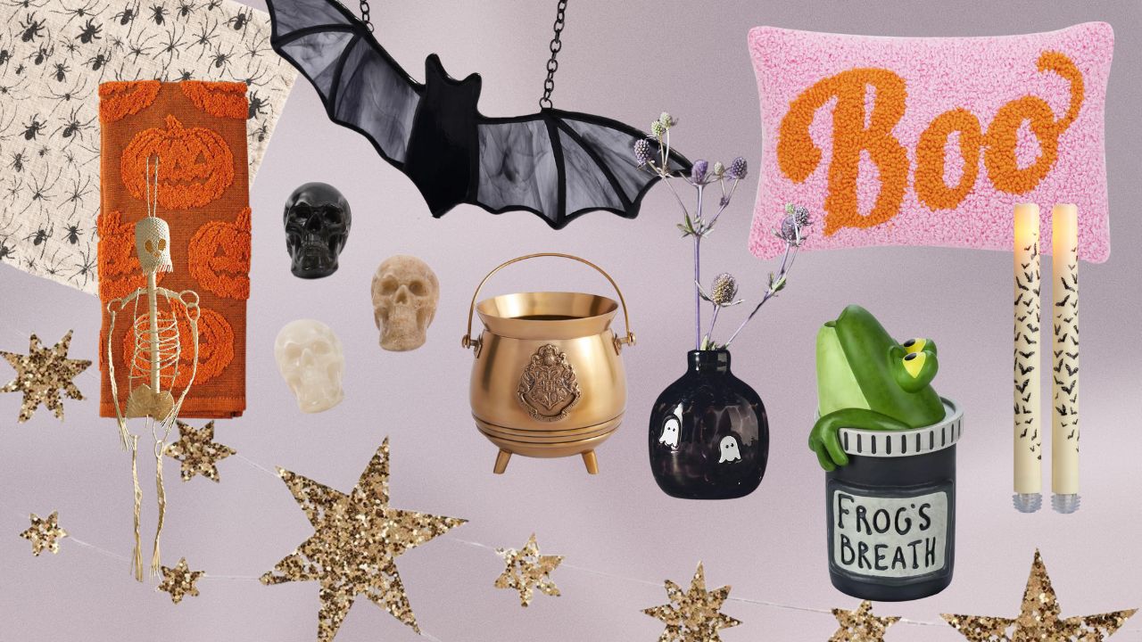 An assortment of Halloween decor. From left to right: a cream table runner with black spiders, an orange kitchen towel, a skeleton, gold glitter star garland, crystal skulls, a stained glass bat, a gold cauldron, a black vase with ghosts, a green frog diffuser, a pink and orange boo pillow, two candlesticks with bats painted on them