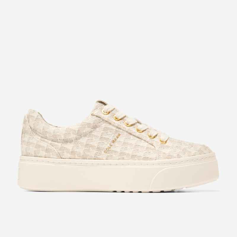 A knit sneaker with white, beige, and brown panels and white and purple contrast stitching