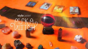 A purple and sparkling crystal ball surrounded by tarot cards and other assorted crystals