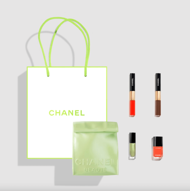 A chanel gift set with four products and a green bag.