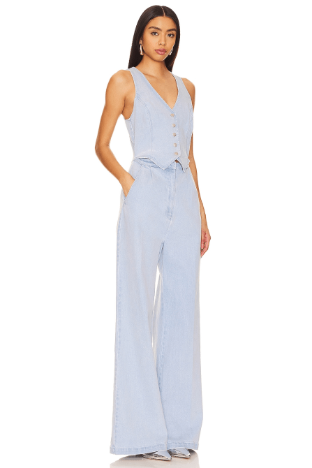 A model wearing the Amanda Uprichard Ethan Jumpsuit in a light denim wash