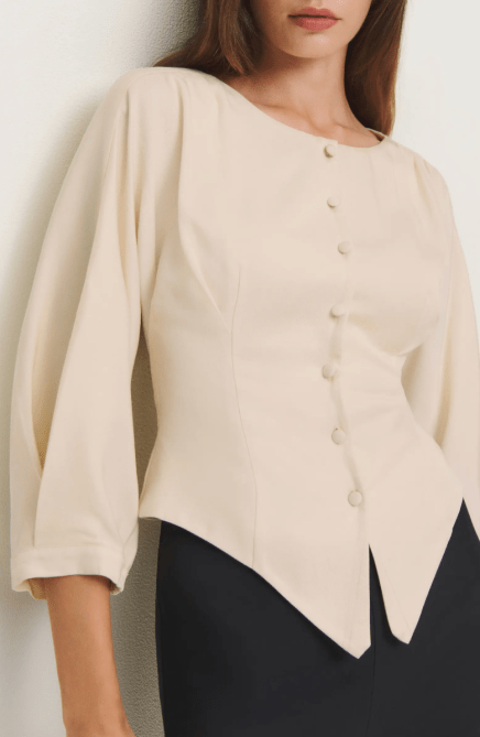 A model wearing the Reformation Martha Front Button Asymmetric Top in ivory
