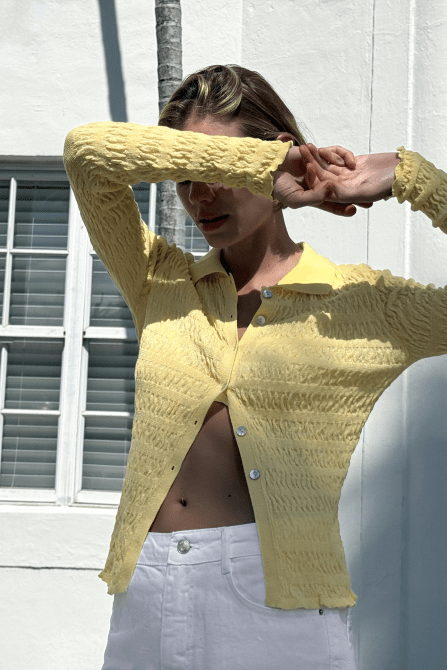 A model wearing the Zara Structured Knit Polo Jacket in yellow