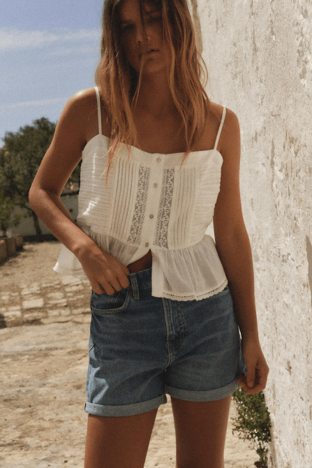 A model wearing the Zara High-Waisted Mom Fit Shorts in a blue denim wash