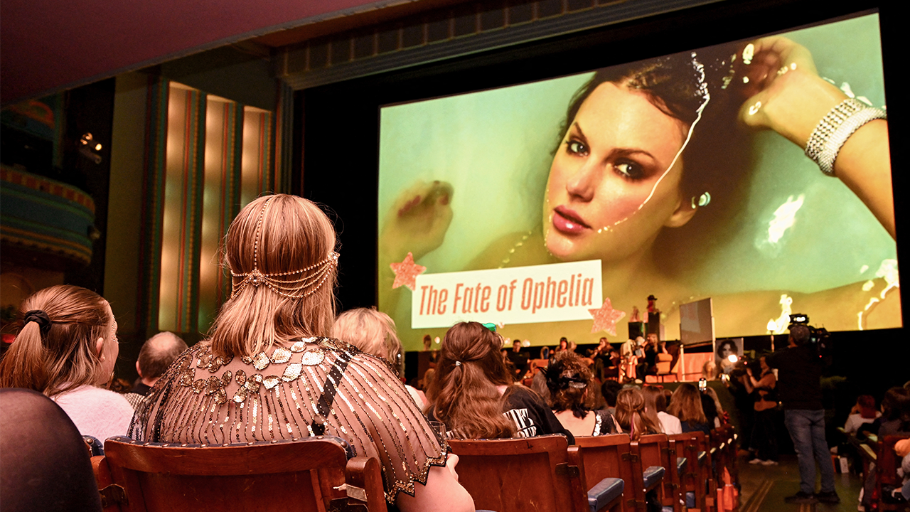 TOPSHOT - Taylor Swift fans listen to a song during a listening event for Swift's new album 'The Life of a Showgirl' at the Astor Theatre in Melbourne on October 3, 2025. Swift on October 3 dropped her 12th studio album, "The Life of a Showgirl," a collection of bouncy pop songs about love, marriage, success -- and score-settling. For the hotly anticipated album, the 35-year-old artist reunited with Swedish hitmakers Max Martin and Shellback, and their influence is clear in the driving beats and catchy hooks. (Photo by William WEST / AFP) (Photo by WILLIAM WEST/AFP via Getty Images)